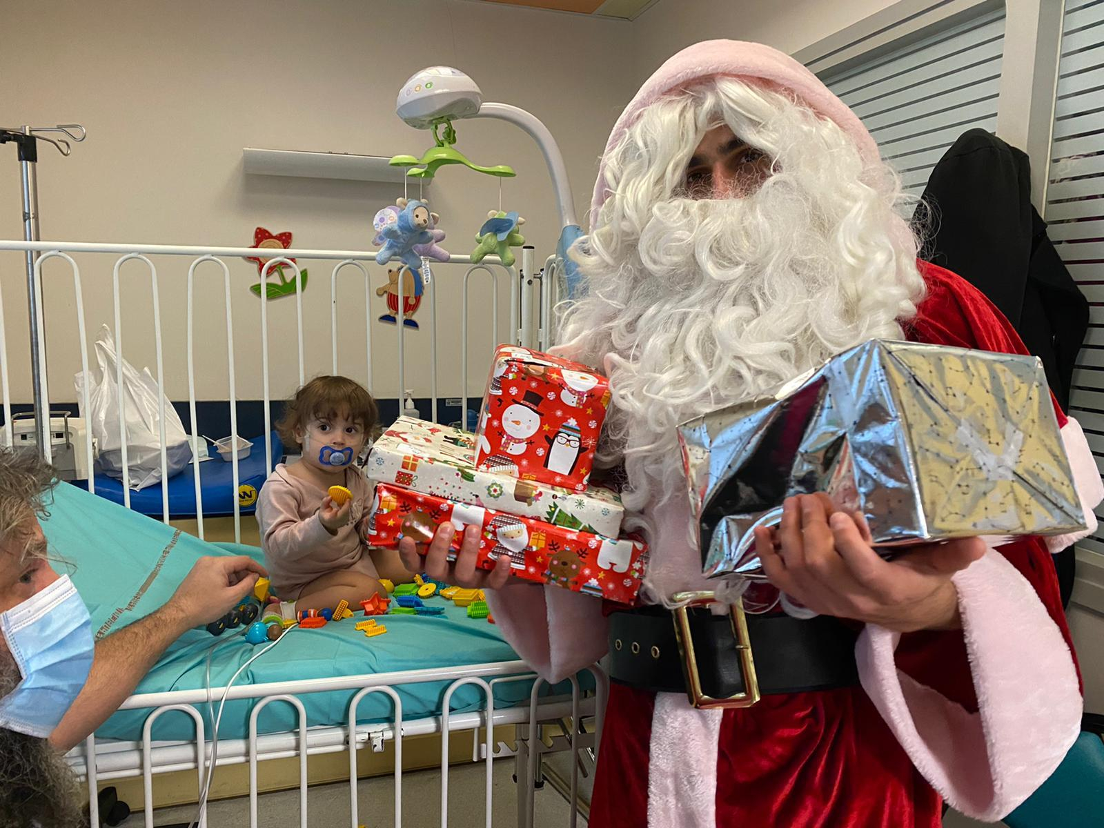 Le père Noël offre un cadeau à un enfant malade